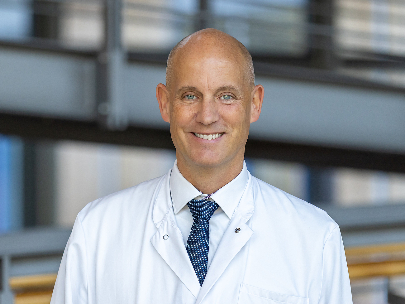 Arzt lächelt in die Kamera.