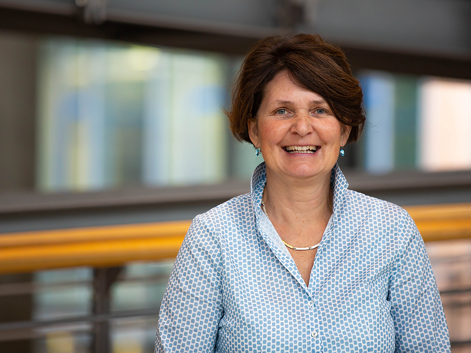 Mitarbeiterin lächelt in die Kamera.