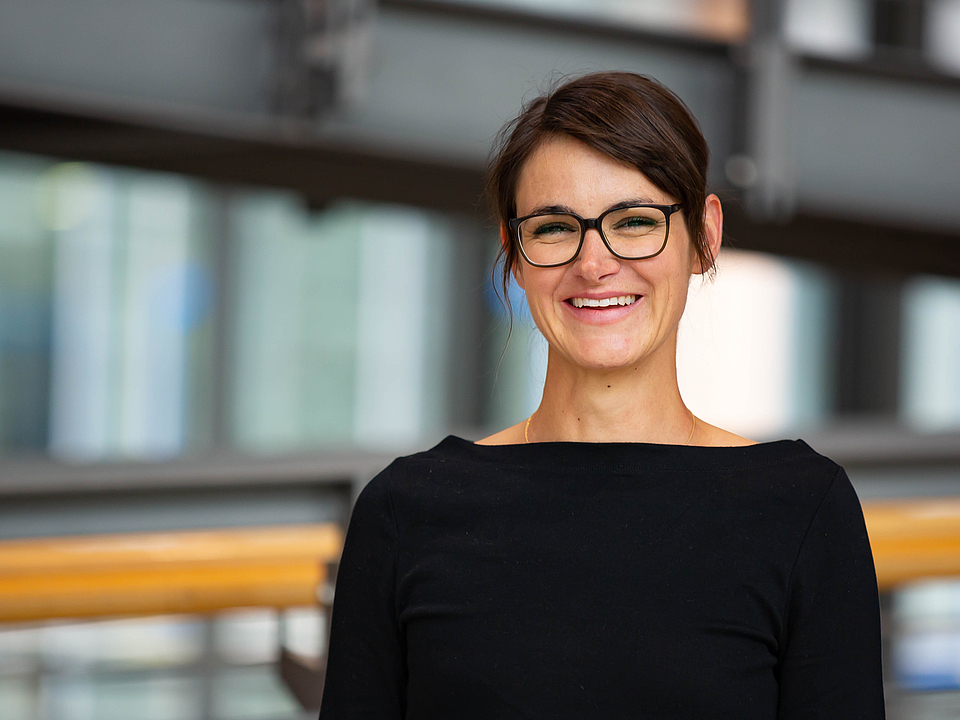 Mitarbeiterin lächelt in die Kamera.