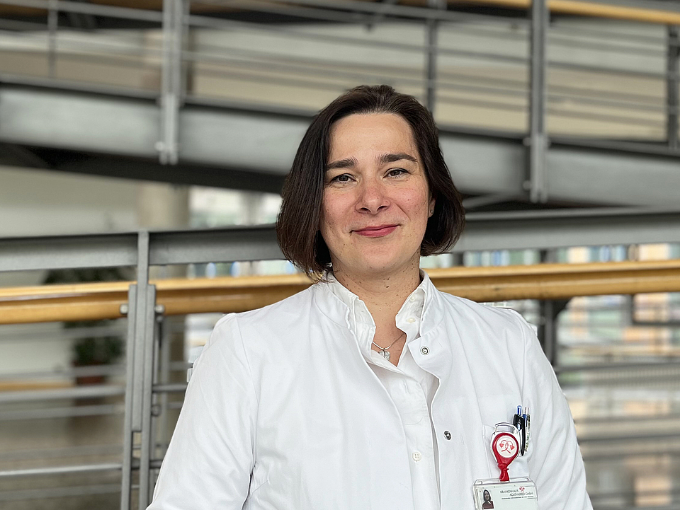 Mitarbeiterin lächelt in die Kamera.