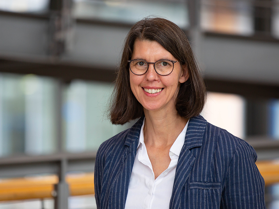 Mitarbeiterin lächelt in die Kamera.