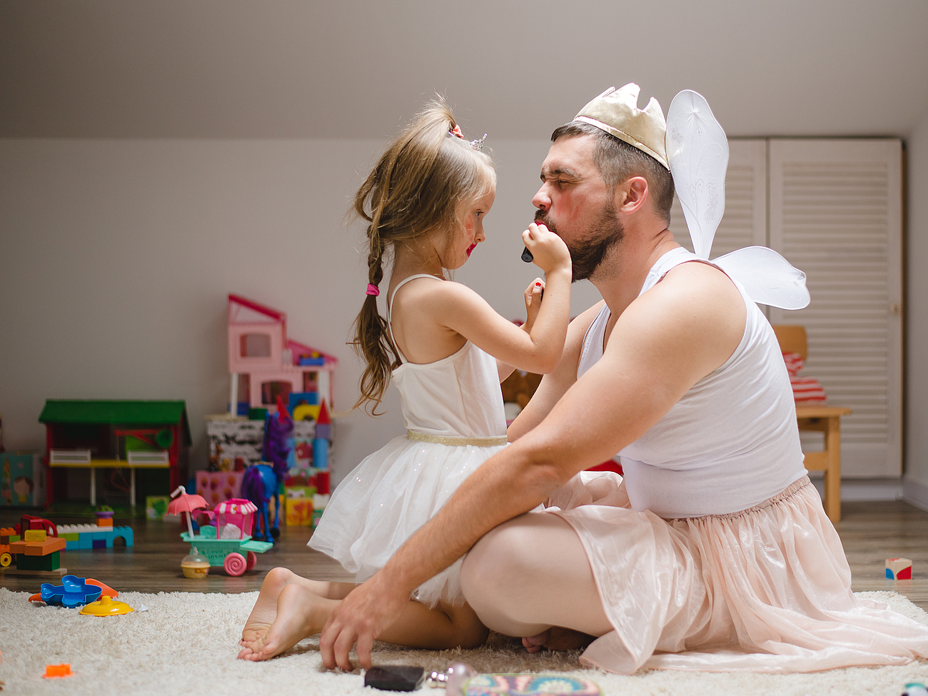 Ein Kind schminkt ihren Vater in einem Köstum