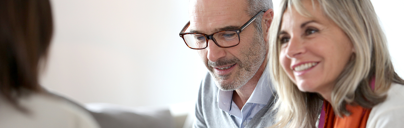 Ehepaar im Gespräch mit Mitarbeiterin des Krankenhauses