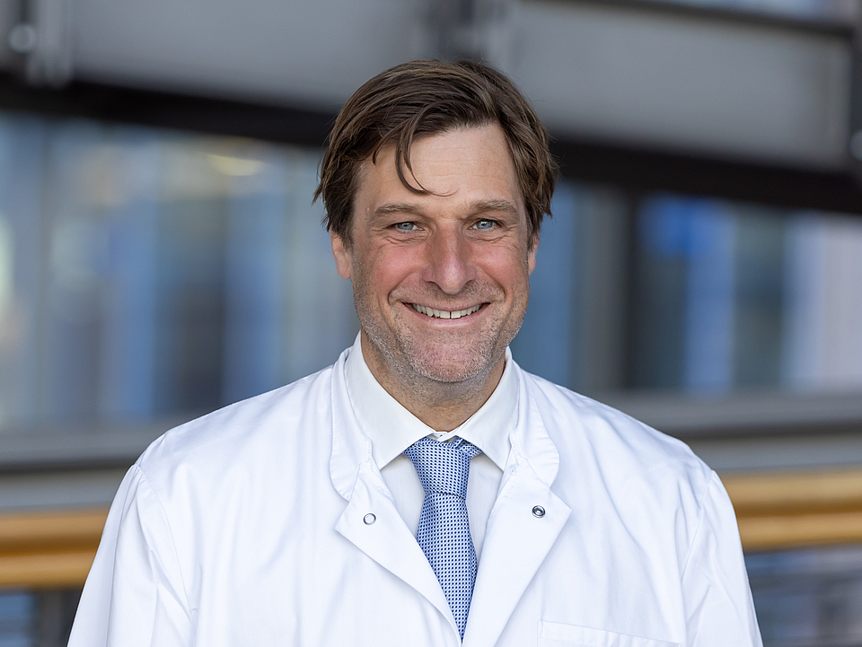 Arzt lächelt in die Kamera.