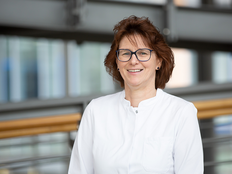 Ärztin lächelt in die Kamera.