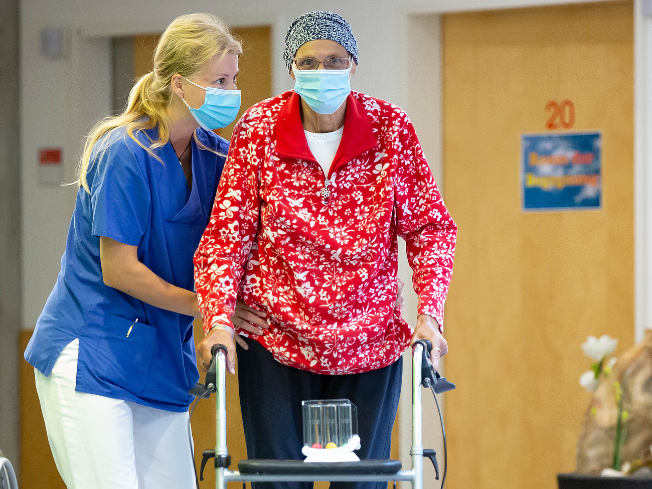 Pflegekraft mit Patientin im Gang der Palliativstation