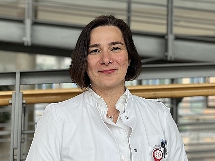 Mitarbeiterin lächelt in die Kamera.