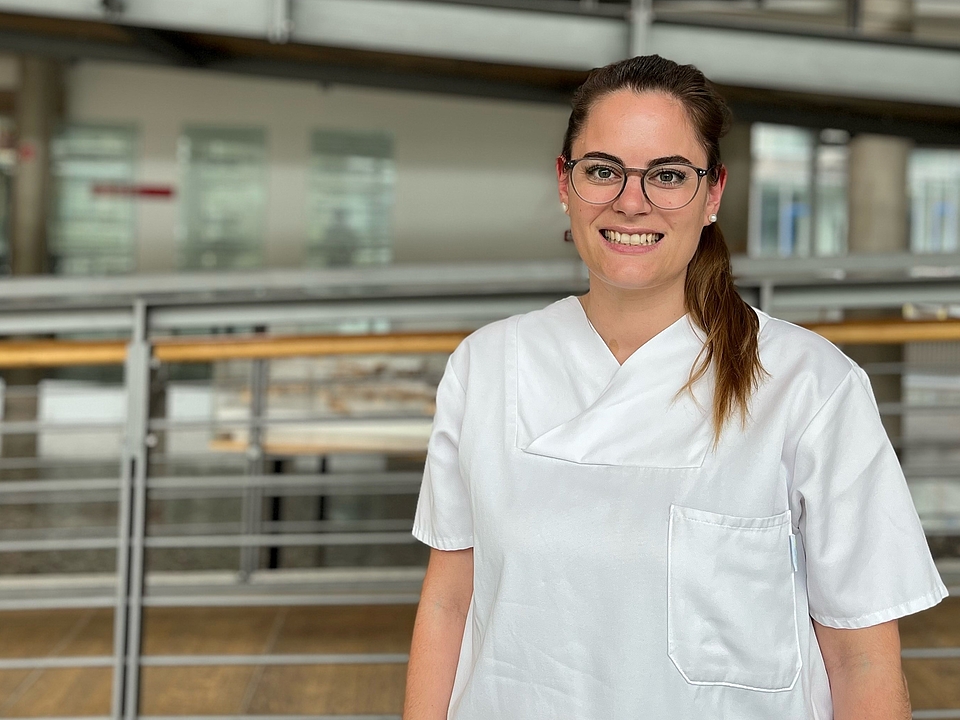 Pflegerin lächelt in die Kamera.