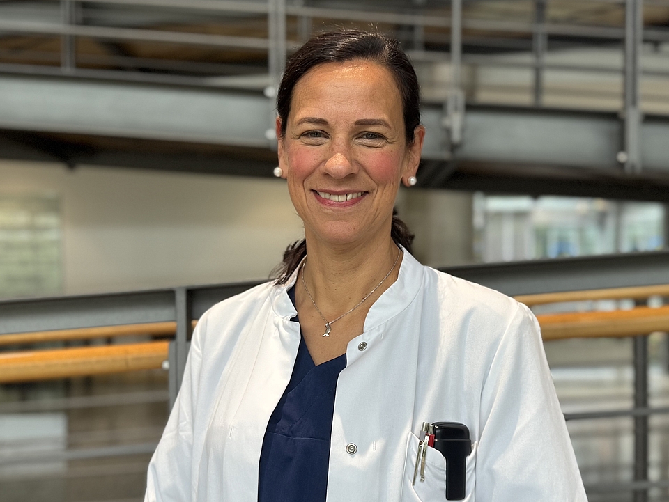 Ärztin lächelt in die Kamera.