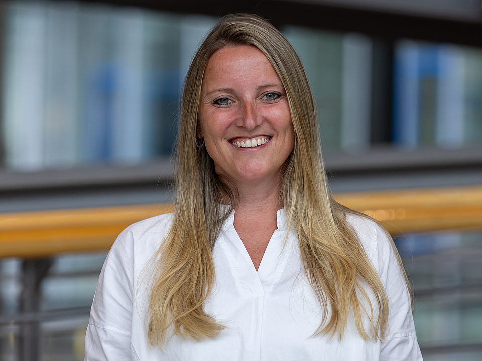 Mitarbeiterin lächelt in die Kamera.