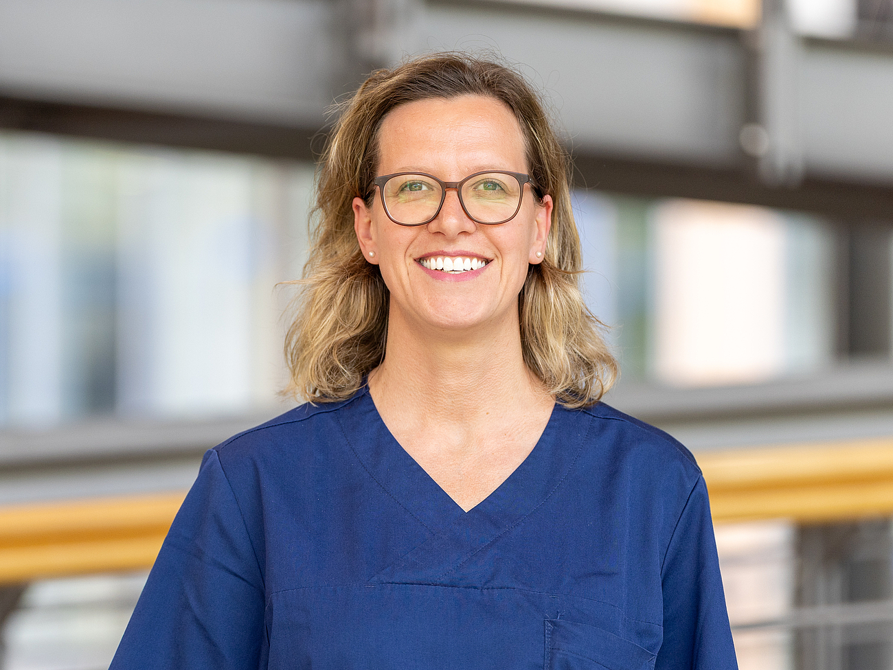 Pflegerin lächelt in die Kamera.