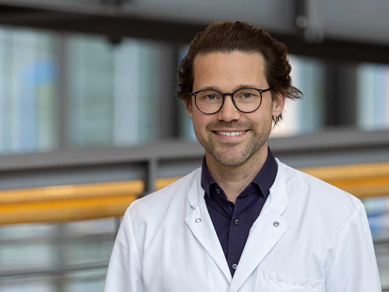 Arzt lächelt in die Kamera.