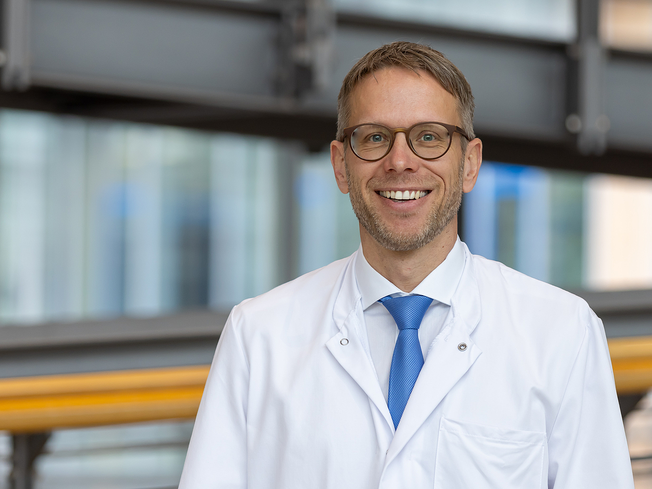 Arzt lächelt in die Kamera.