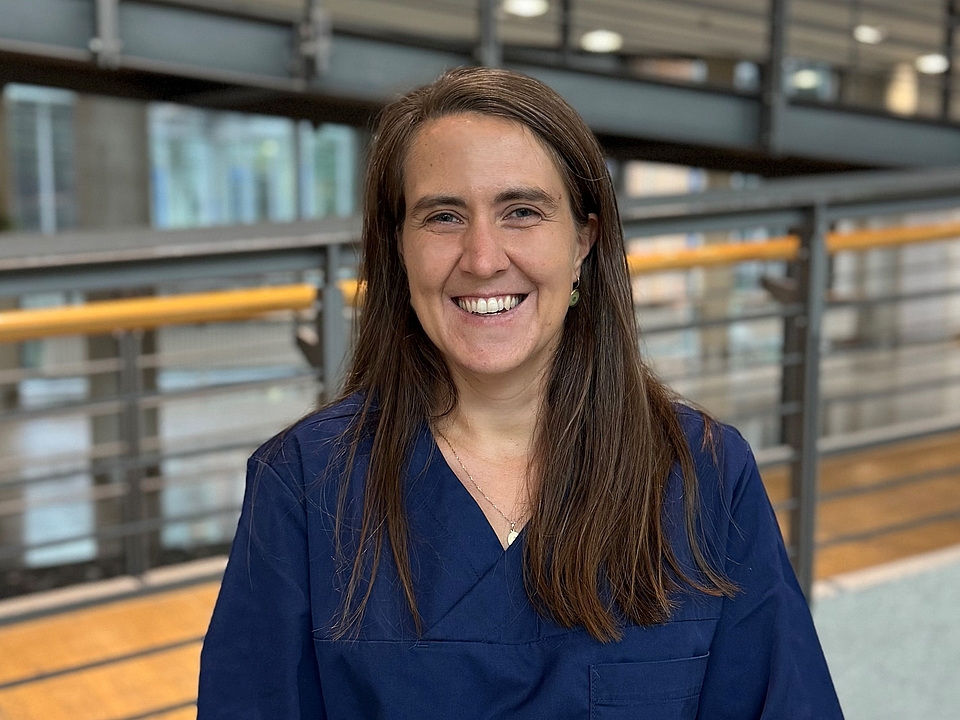 Pflegerin lächelt in die Kamera.