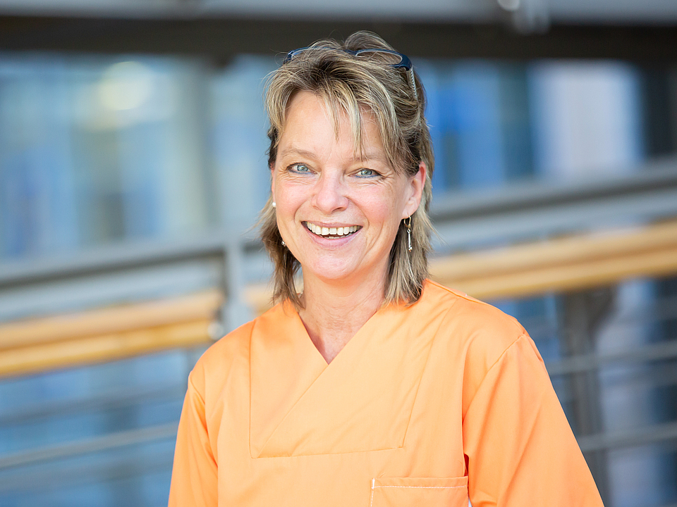 Pflegerin lächelt in die Kamera.