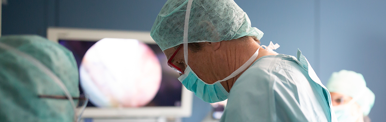 Prof. Brunner steht mit Maske im OP.
