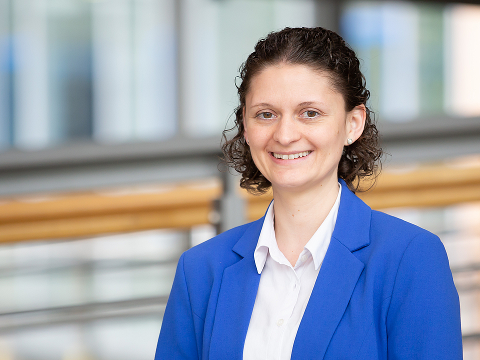 Mitarbeiterin lächelt in die Kamera.