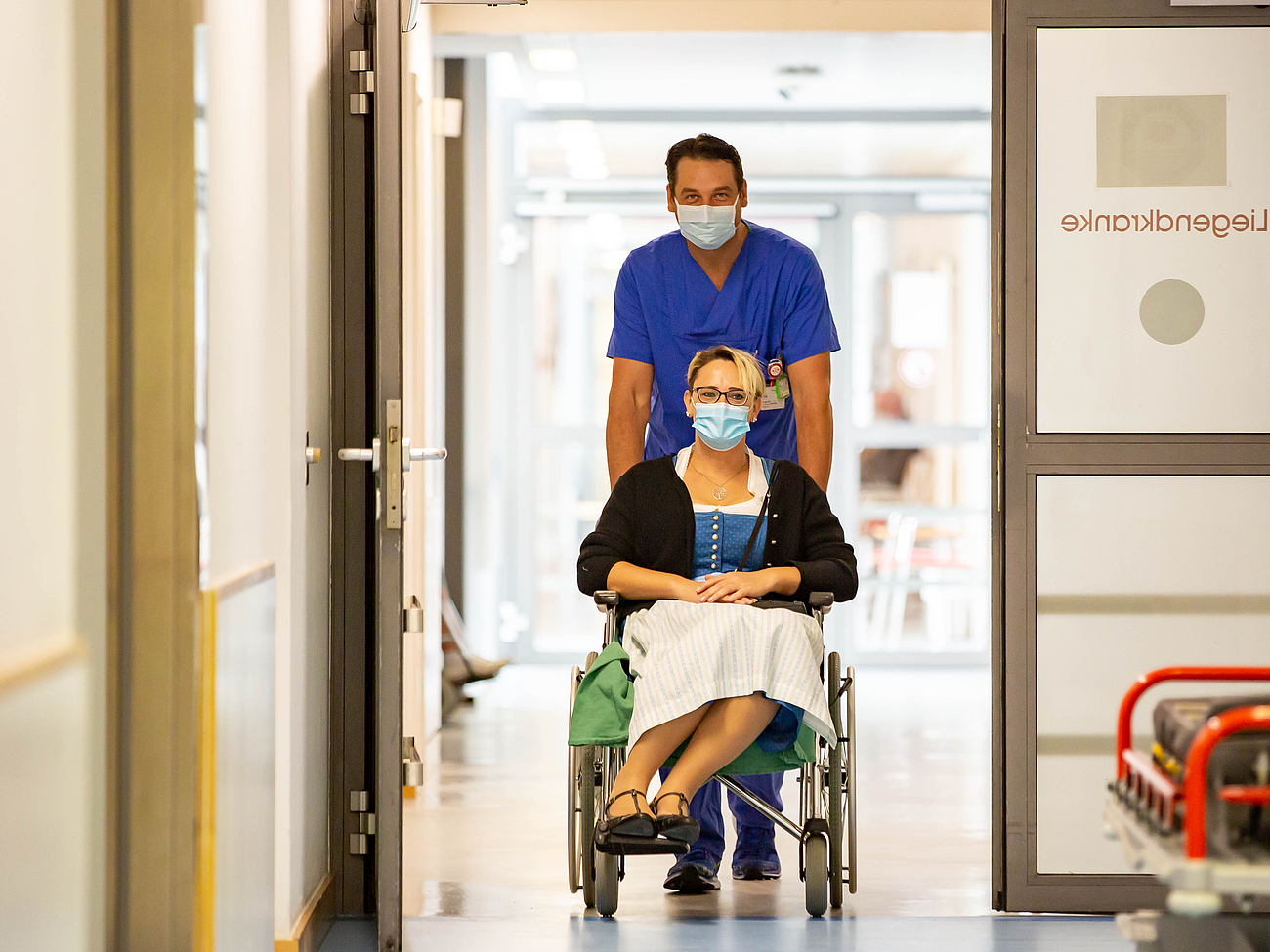 Patientin wird im Rollstuhl in die Notaufnahme gebracht