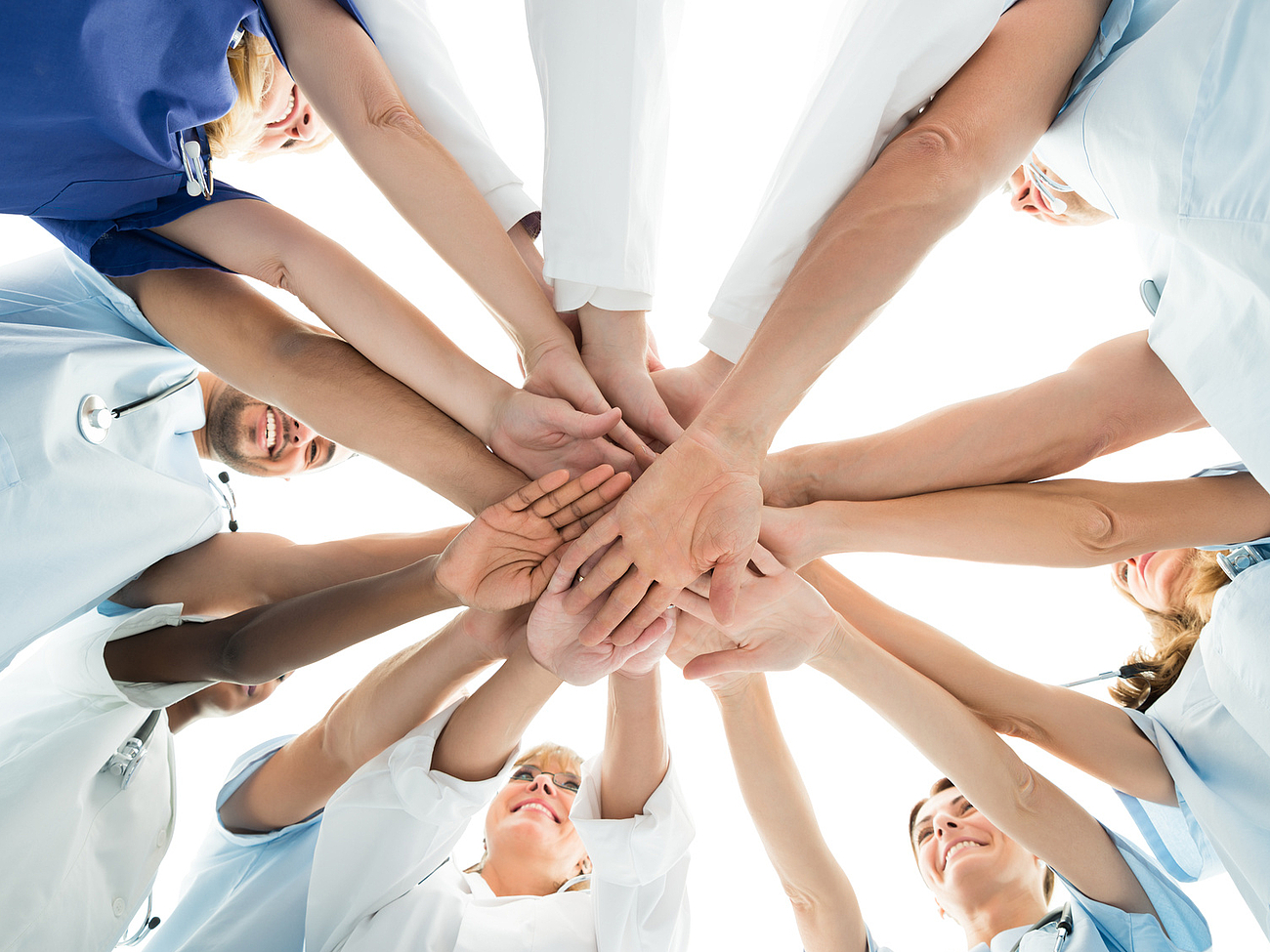 Unser Team arbeitet Hand in Hand Mitarbeiter bilden einen Kreis und legen die Hände aufeinander