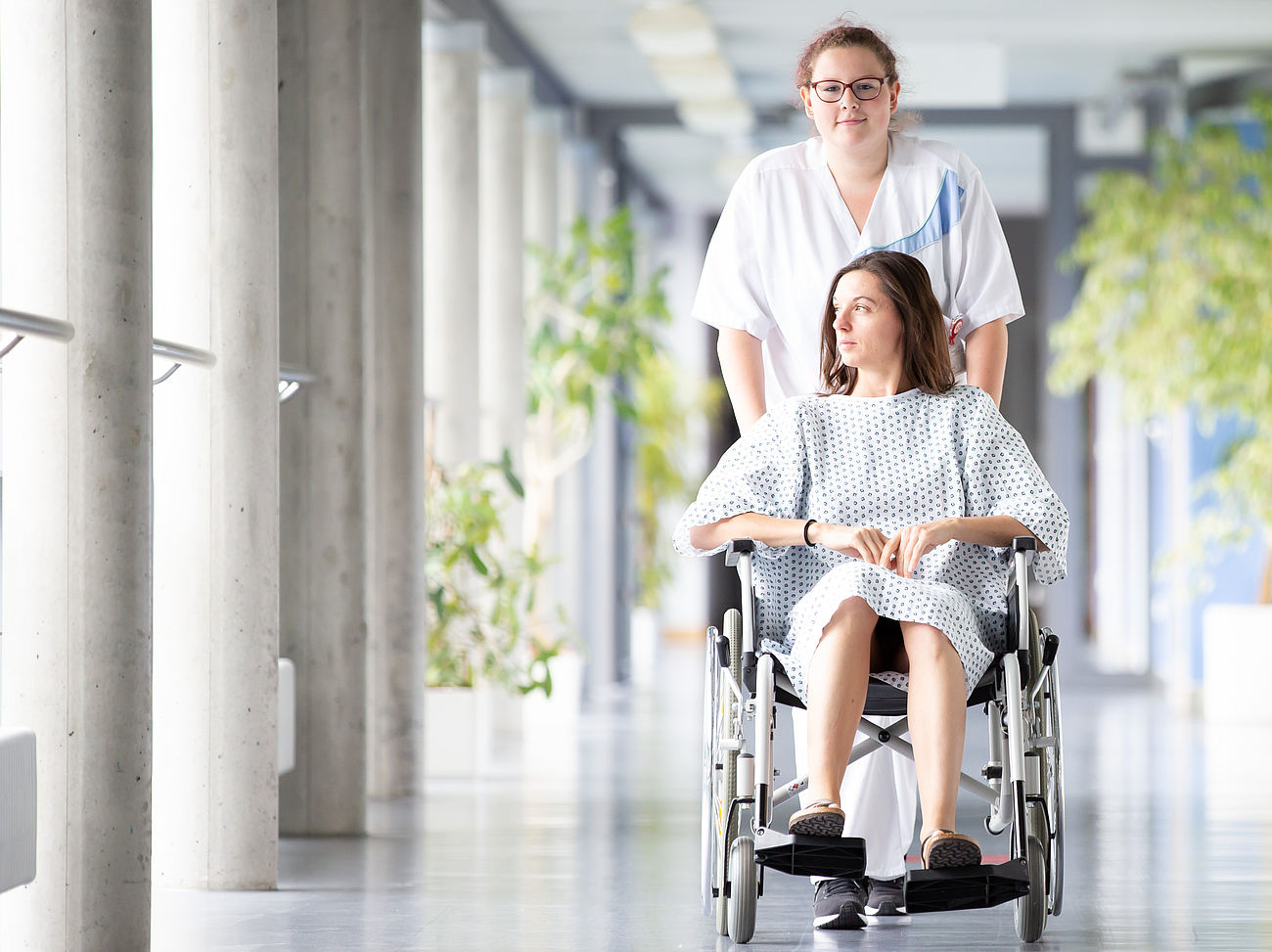 Schwester schiebt Patientin durch den Flur Schwester schiebt Patientin durch den Flur