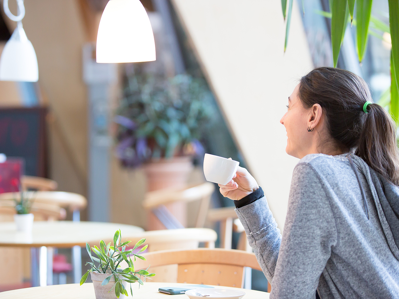 Patient im Bistro Eine Patientin sitzt im Bistro und trinkt einen Kaffee.